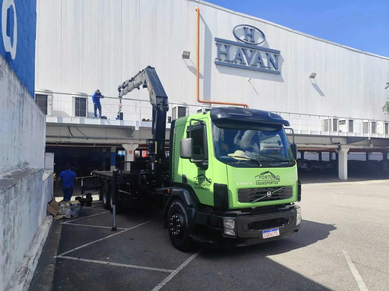 Caminhão munck em operação de içamento em loja Havan